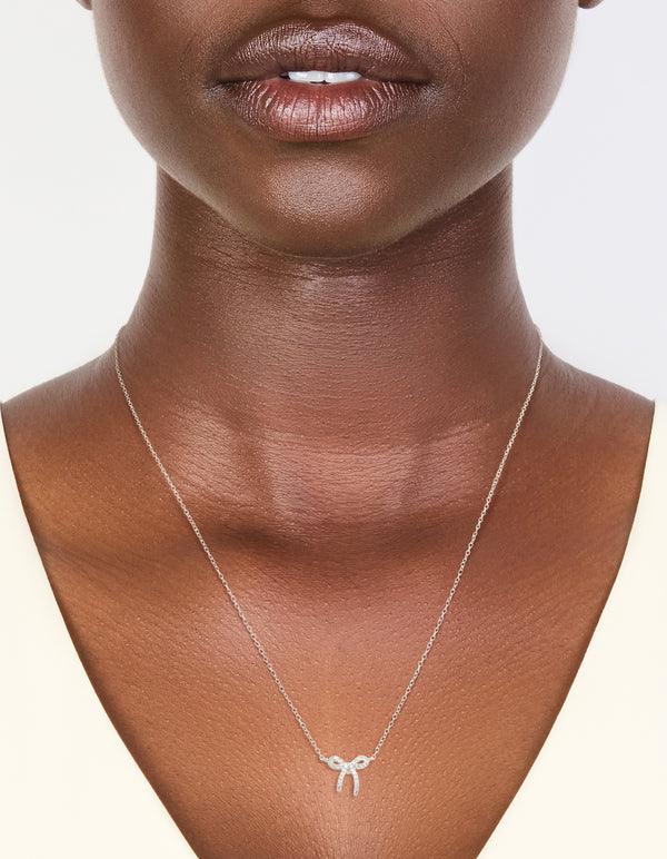 Featuring a sterling silver cubic zirconia bow pendant necklace with dainty on neck view