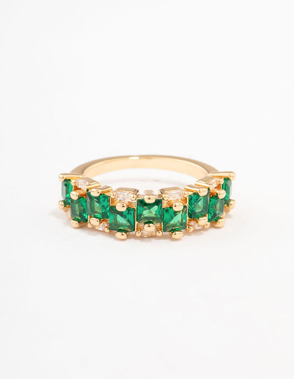 A gold plated staggered band ring crafted with emerald cut cubic zirconia in dark green close up view