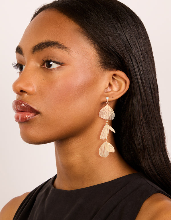 Designed with gold lazercut petal drop earrings featuring floral elements on model view