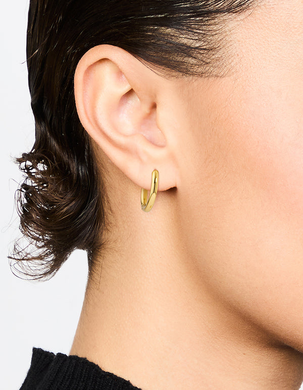 Featuring waterproof gold plated stainless steel core clicker earrings 14 MM with huggie closure on ear view