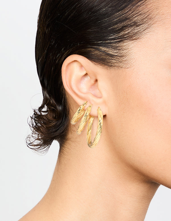Crafted from waterproof gold plated stainless steel twisted hoop earrings in a 3-pack on ear view