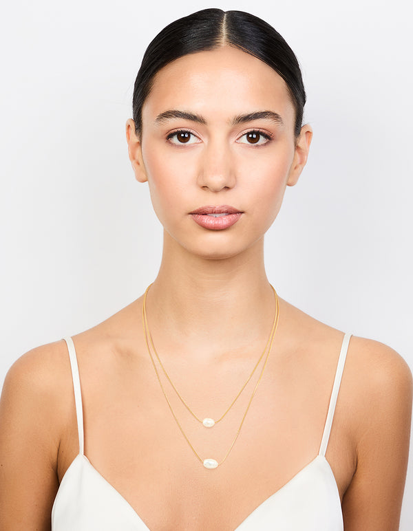 Featuring a waterproof gold plated stainless steel layered pearl pendant necklace on model view