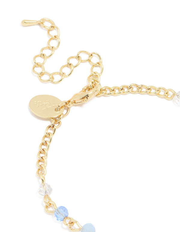 Elegant gold plated bracelet with blue beads featuring cross accents closure detail view