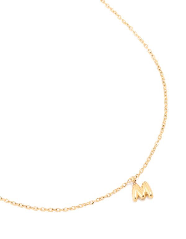 Expertly crafted waterproof letter M necklace in gold plated stainless steel with bubble initial pendant in a dainty style close up view