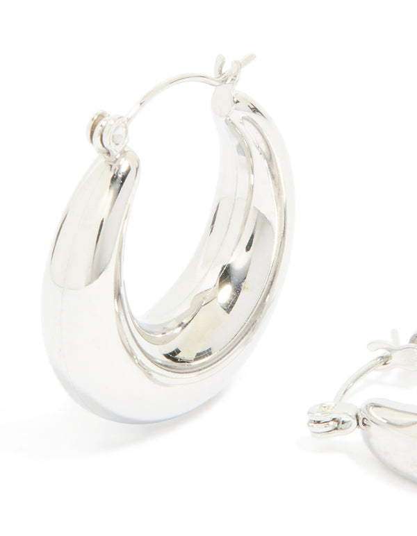 Highlighting waterproof stainless steel small chunky huggie earrings with closure in silver close up view