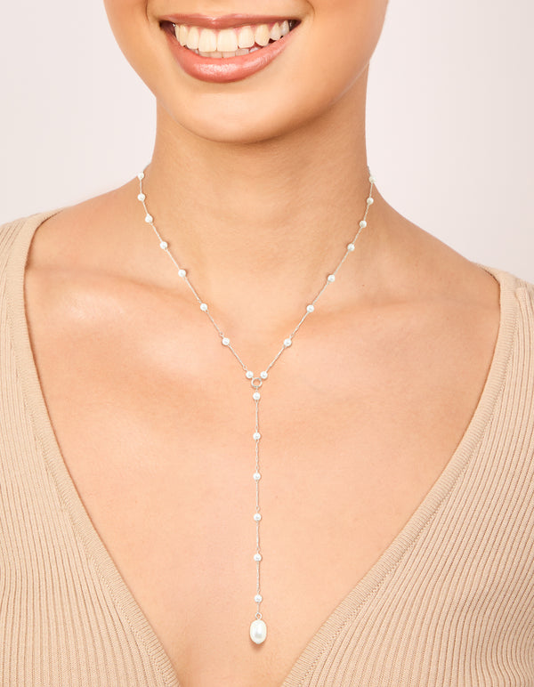 Showcasing a waterproof stainless steel pearl Y-necklace in silver and white on neck view