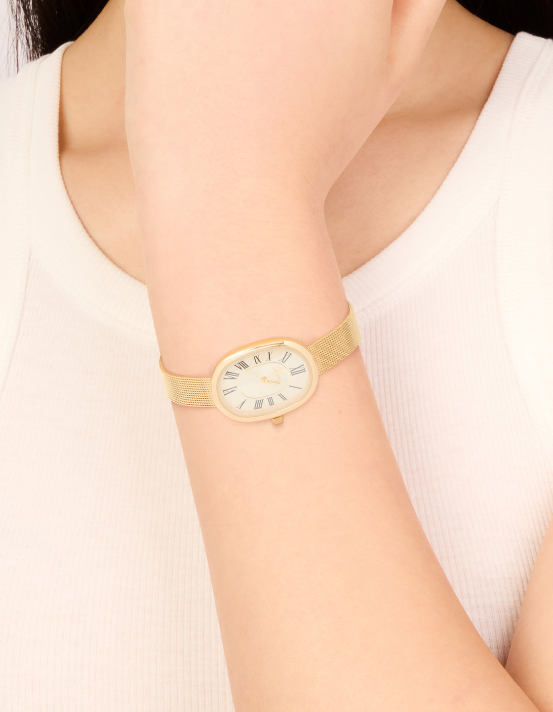 Elegant gold vintage mesh oval face watch with beige dial roman numerals designed for women featuring formal analog styling on wrist view