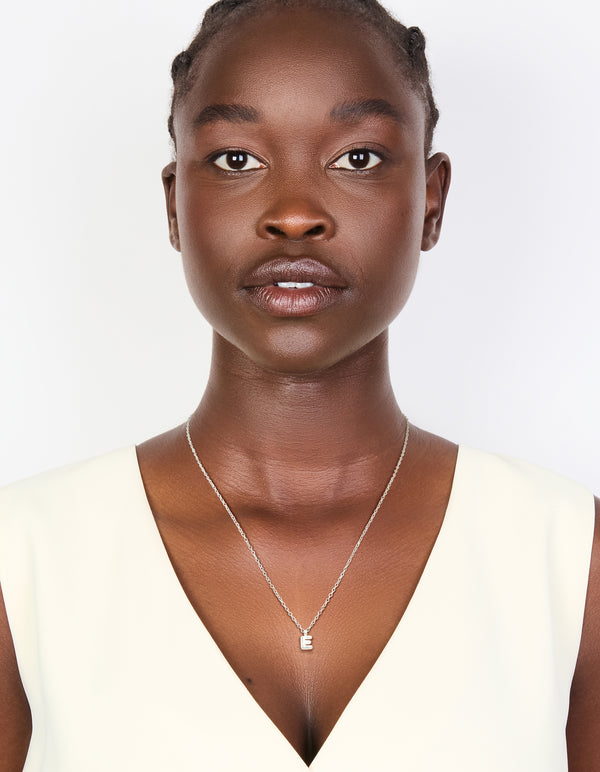 Elegant waterproof stainless steel mini bubble letter E necklace with initial pendant in silver on model view