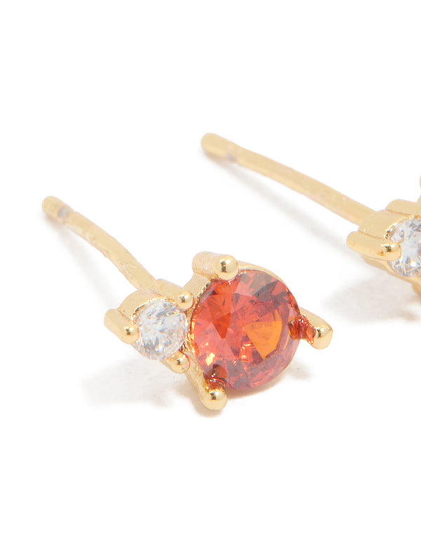 Crafted from waterproof stainless steel dainty stud earrings in coral and clear cubic zirconia stones in gold plated finish close up view