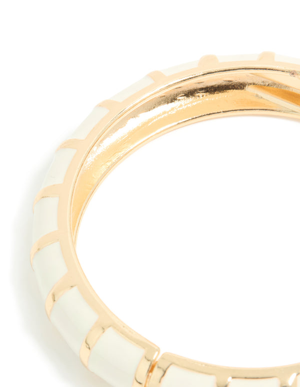Designed with striped enamel in gold and ivory, this bangle showcases its curved structure close up view