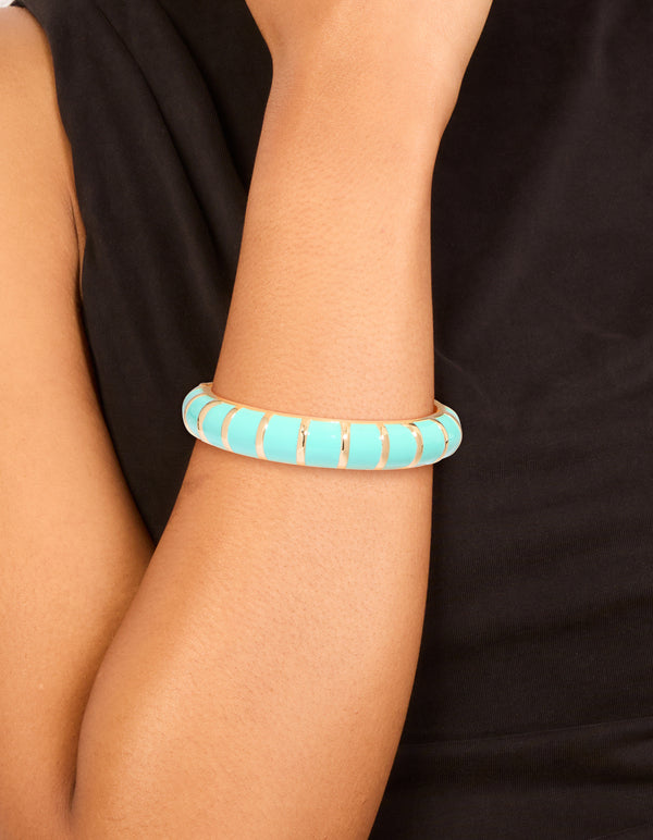 Showcasing an aqua enamel stripe bangle in gold on wrist view