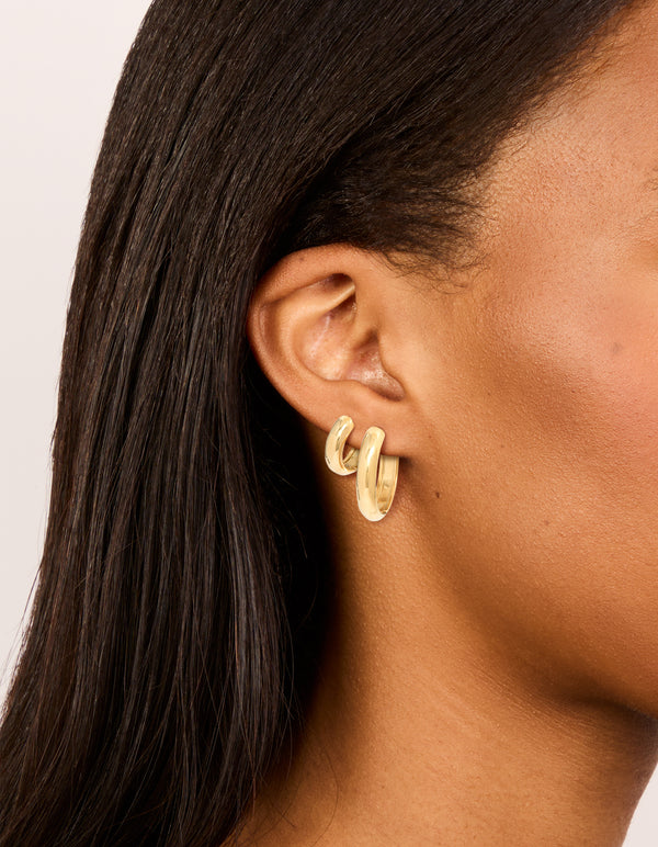 Featuring waterproof gold plated stainless steel thick, small and large hoop earrings in a 2-pack with chunky statement styling on ear view
