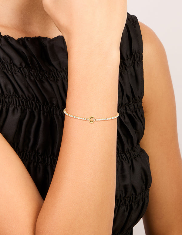 Showcasing a waterproof tennis bracelet with letter C initial, crafted from gold plated stainless steel and featuring cubic zirconia stones on wrist view