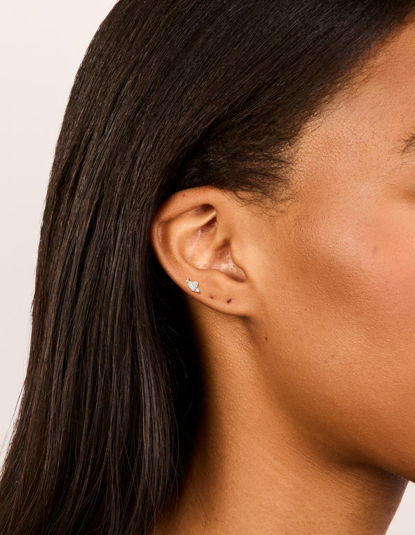 Showcasing heart arrow flat back stud earrings crafted from surgical steel with cubic zirconia in silver on ear view