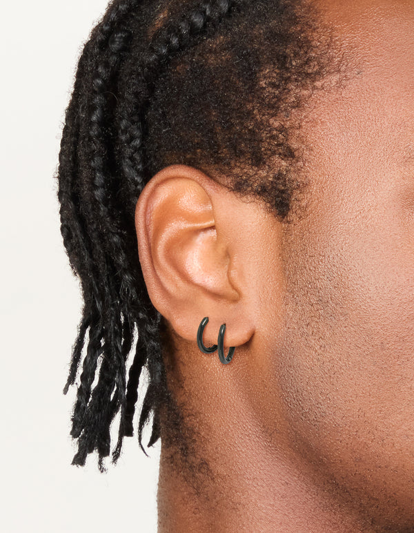 Showcasing mens waterproof black coated stainless steel huggie earrings in a 2-pack on ear view