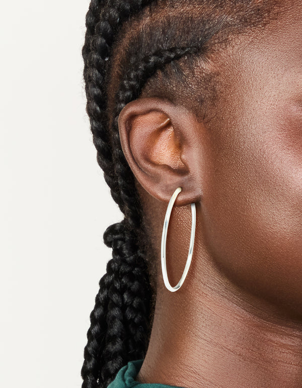 Discover large thin hoop earrings crafted from silver plated material with hoop closure on ear view