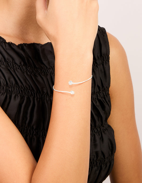 Showcasing a silver plated cubic zirconia floating wrap around bangle with statement style on wrist view