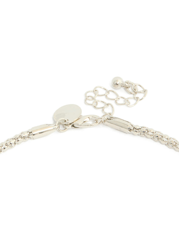 Capturing a silver necklace with black diamante cross pendant clasp detail view