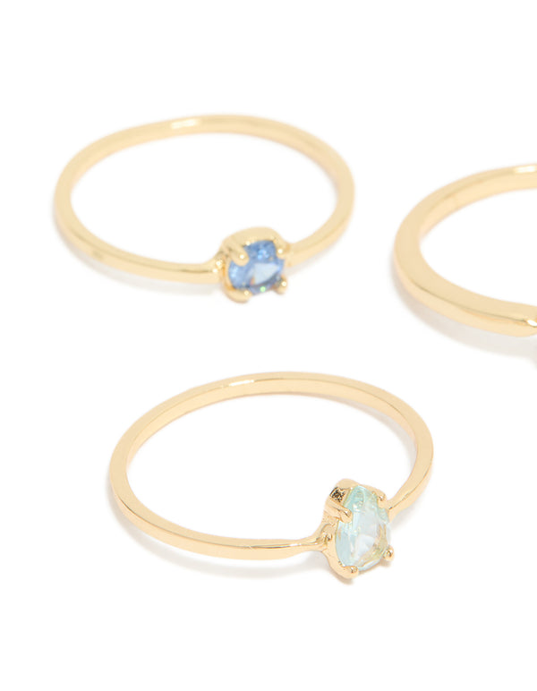Showcasing gold plated blue cubic zirconia and bubble rings in a stackable 5-pack with oval, round, and heart stone details, close up view