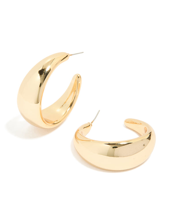 Showcasing chunky hoop earrings in gold front view