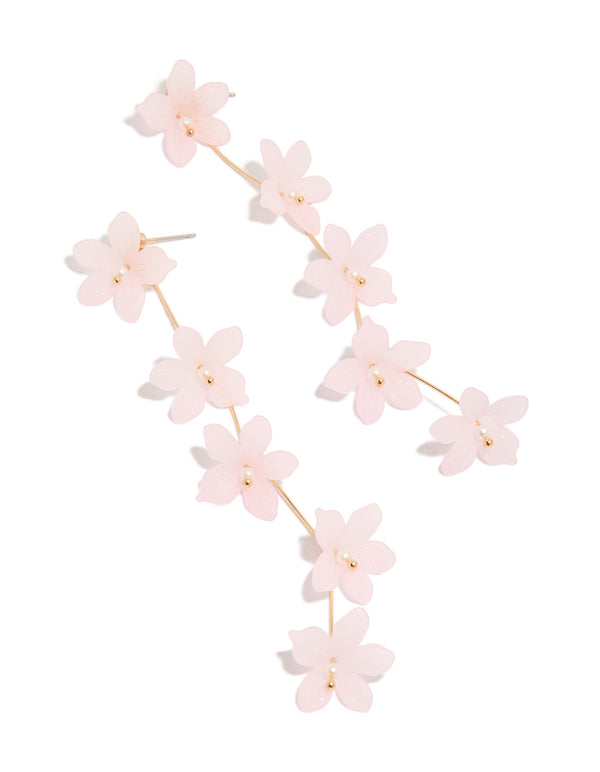 Showcasing gold statement drop earrings with beaded accents and pink floral detailing in front view