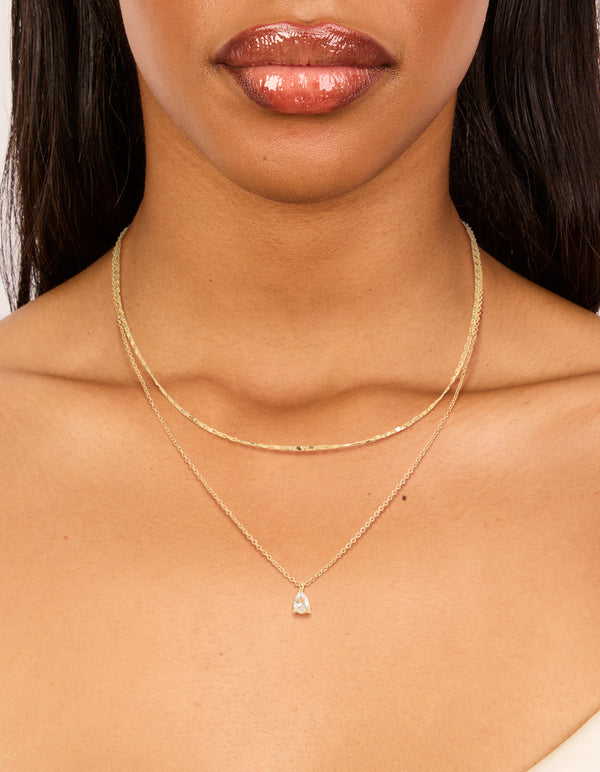 Elegantly designed gold plated necklace with pear cut cubic zirconia pendant featuring chain in a 2-pack on neck view