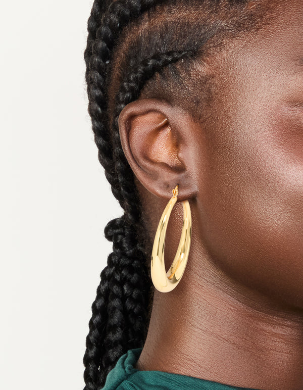 Crafted from gold plated material, thick thin hoop earrings with closure on ear view
