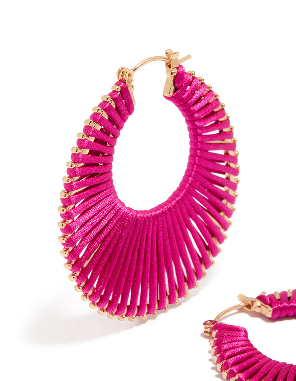 Capturing hot pink threaded hoop earrings gold accents close up view