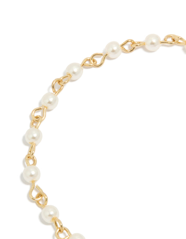 Highlighting the gold plated chain design of pearl and cubic zirconia bracelet featuring celestial star moon charm fob closure detail view