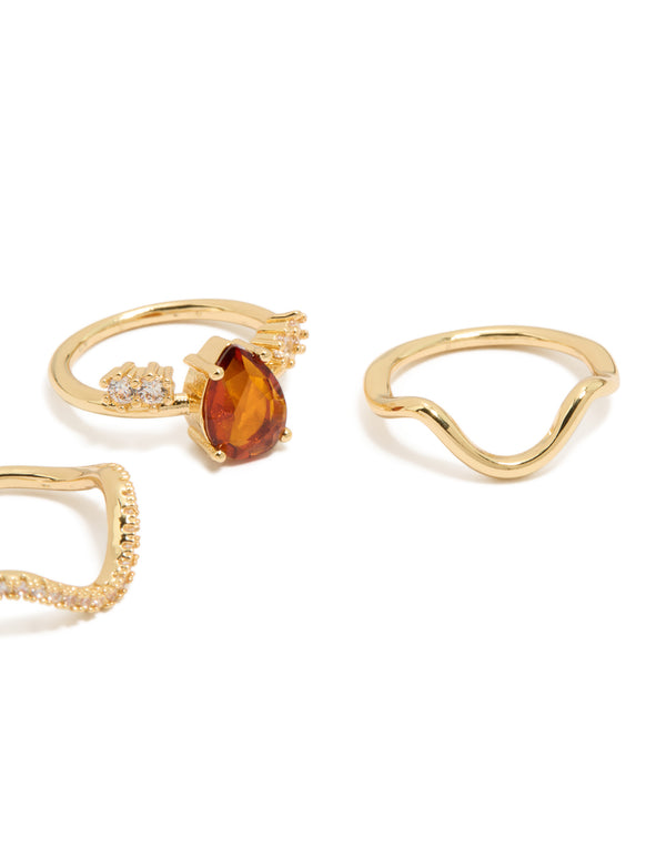 Featuring gold plated red cubic zirconia teardrop and wavy rings 3-pack with crystal embellishments in statement style close up view