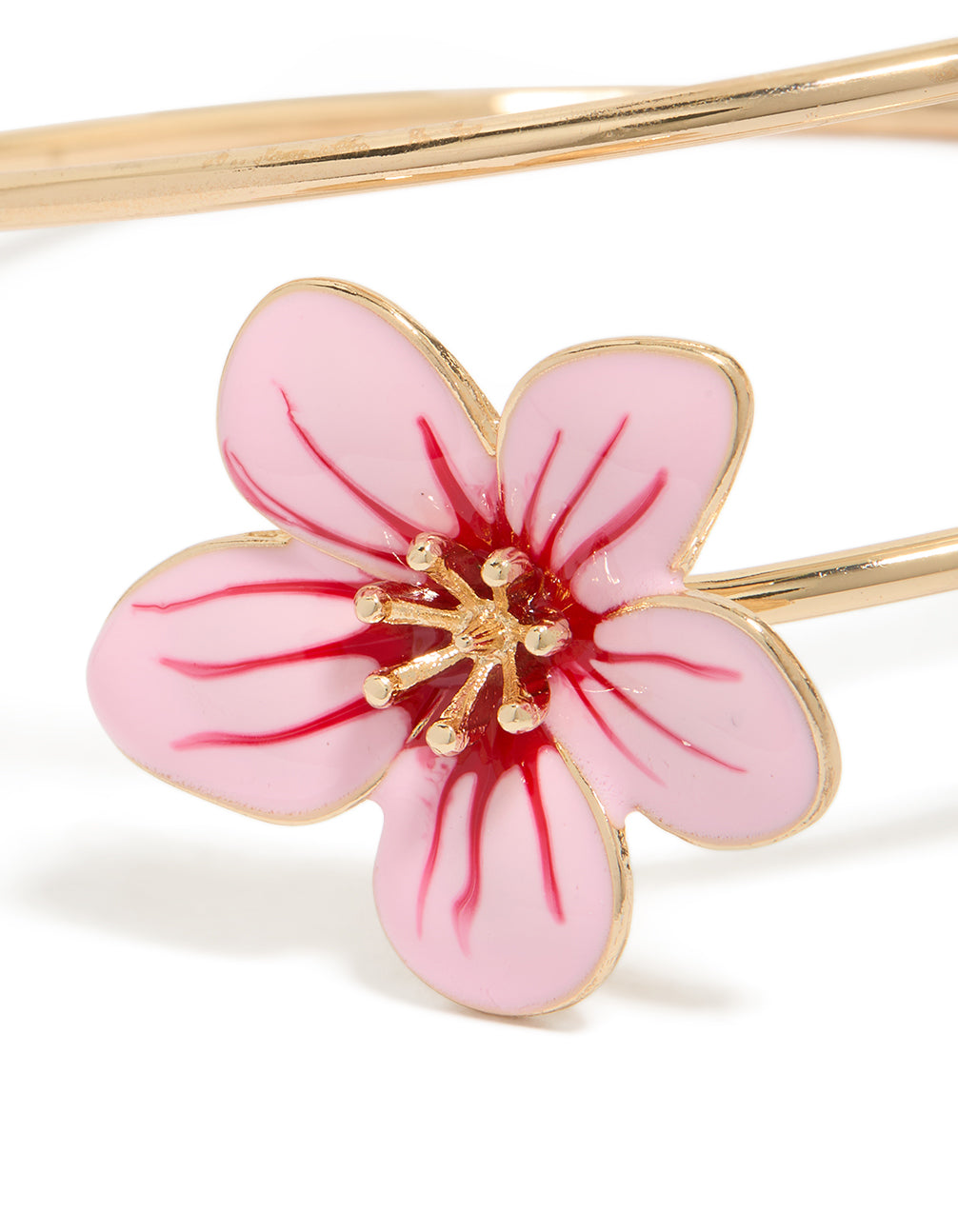 Highlighting a gold pink with red centre enamel flower arm cuff featuring floral pattern in statement style bangle close up view