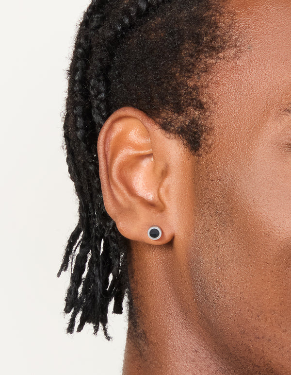 Featuring waterproof black coated stainless steel round flat back studs in silver on ear view