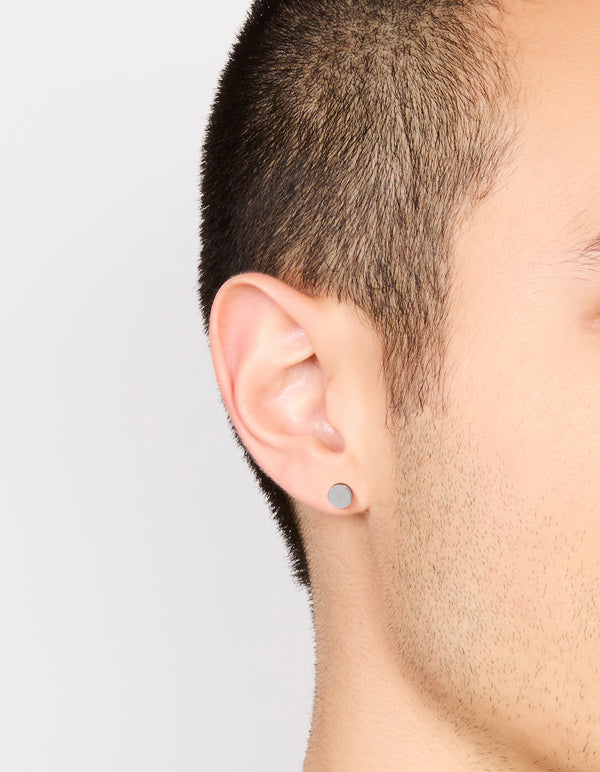 Featuring mens waterproof stainless steel round flat back stud earrings in silver and black on ear view
