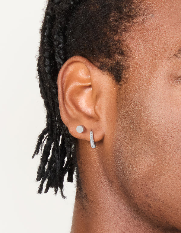 Featuring waterproof men's stainless steel flat stud and huggie earrings in a 2-pack with silver finish on ear view