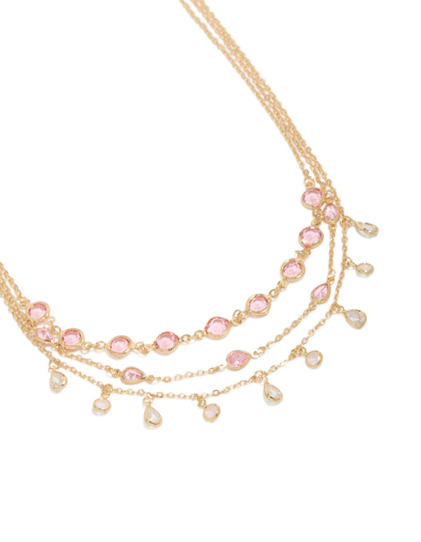 Featuring a gold pink diamantes triple layered necklace with charm detailing in a statement style close up view