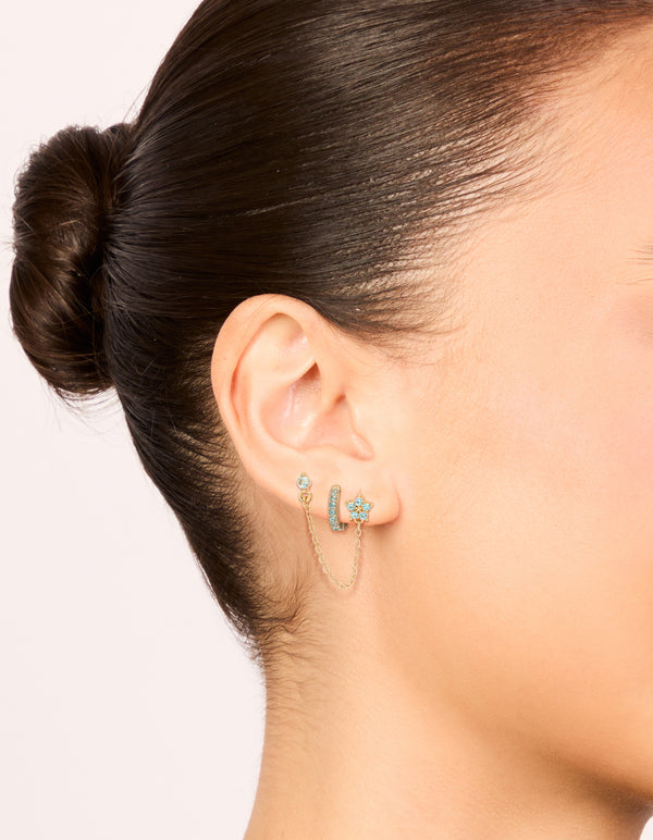 Featuring gold light blue cubic zirconia chain flower and huggie earrings pack on ear view