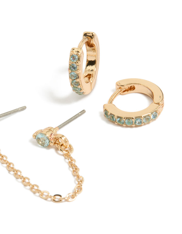 Designed with floral chain and light blue cubic zirconia crystal huggie earrings in gold close up view