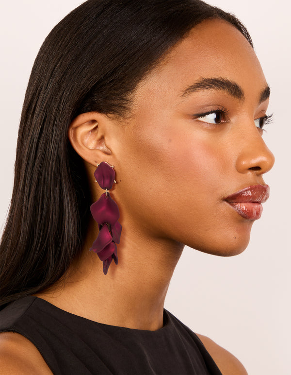 Featuring statement burgundy coated metal petal drop earrings in maroon and gold on model view