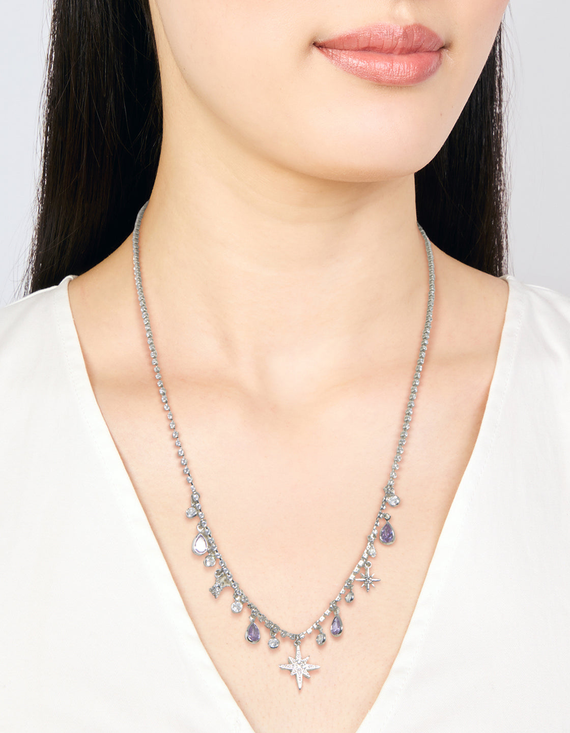 Elegant silver lilac cubic zirconia teardrops and celestial star charms necklace with pear shape crystal features on neck view