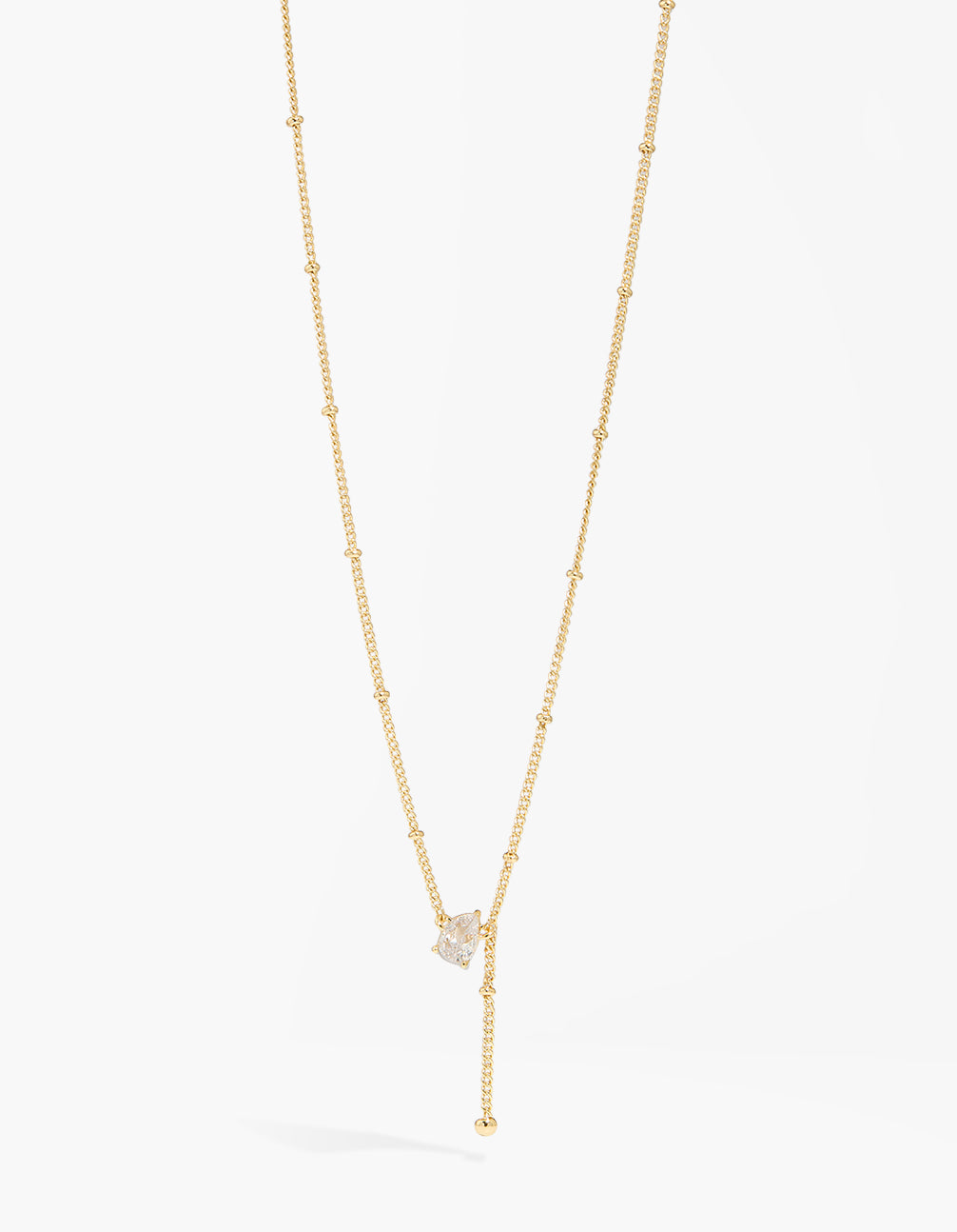 Showcasing a ball chain cubic zirconia Y-necklace with statement styling in gold plated finish close up view
