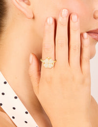 Beautifully crafted waterproof gold plated stainless steel spinning clover ring featuring floral and heart design on finger view - link has visual effect only