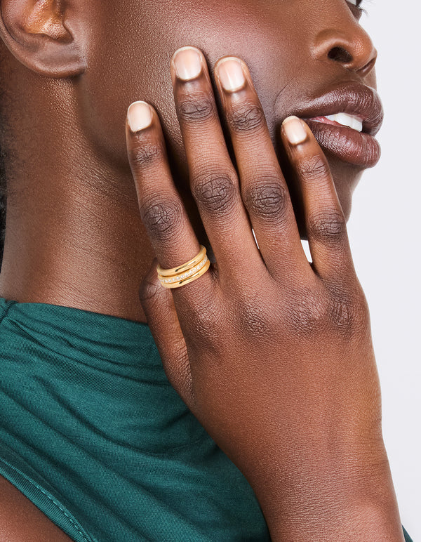 Showcasing waterproof gold plated triple band stacking rings in a 3-pack on finger view