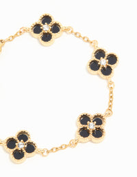Detailed view of waterproof charm floral bracelet in gold plated stainless steel featuring diamante black inlay flowers close up view - link has visual effect only