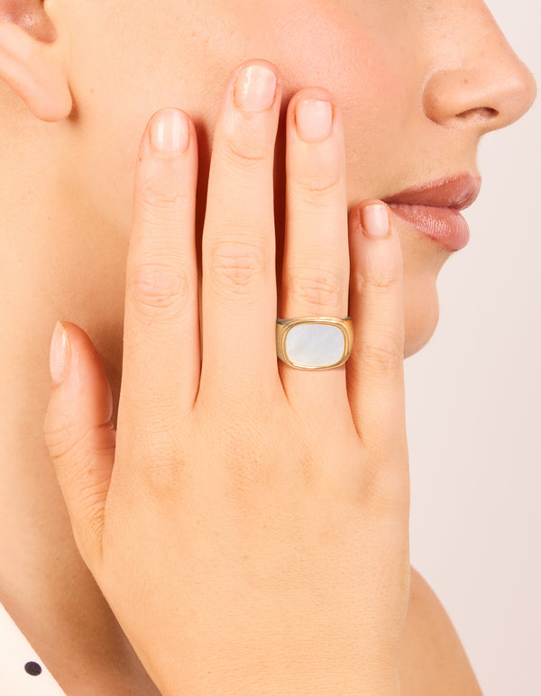Showcasing a waterproof chunky signet ring crafted from gold plated stainless steel with square semi precious moonstone on finger view