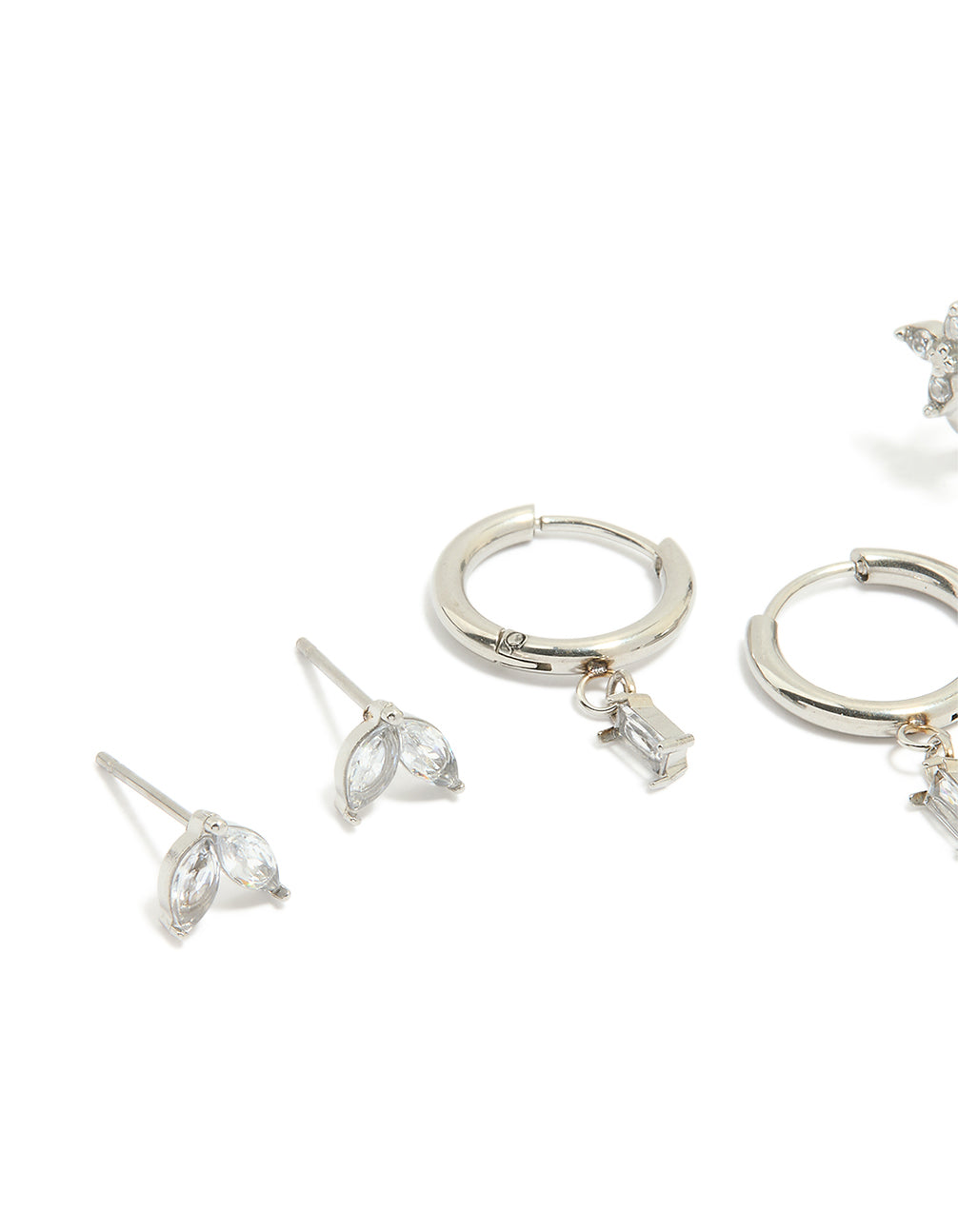 Featuring waterproof stainless steel cubic zirconia and baguette flower huggie earrings in a 4-pack with floral design in silver and clear stones close up view