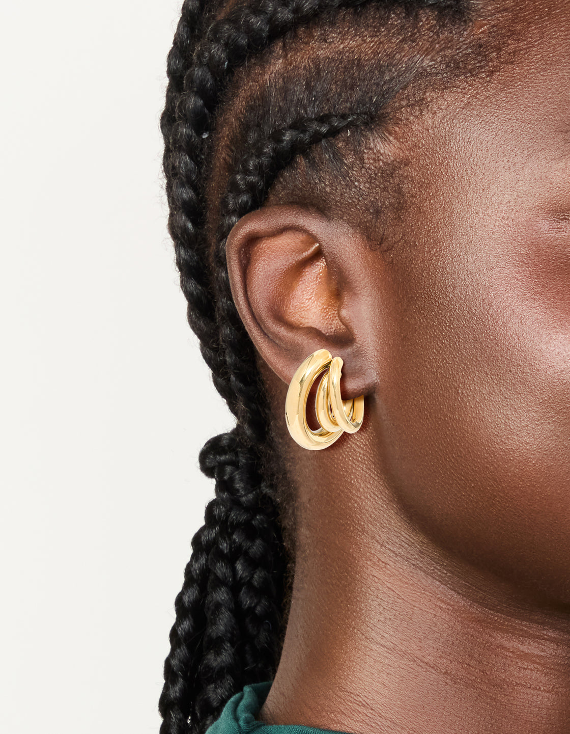 Showcasing waterproof stainless steel triple illusion hoop earrings in statement style with gold finish on ear view