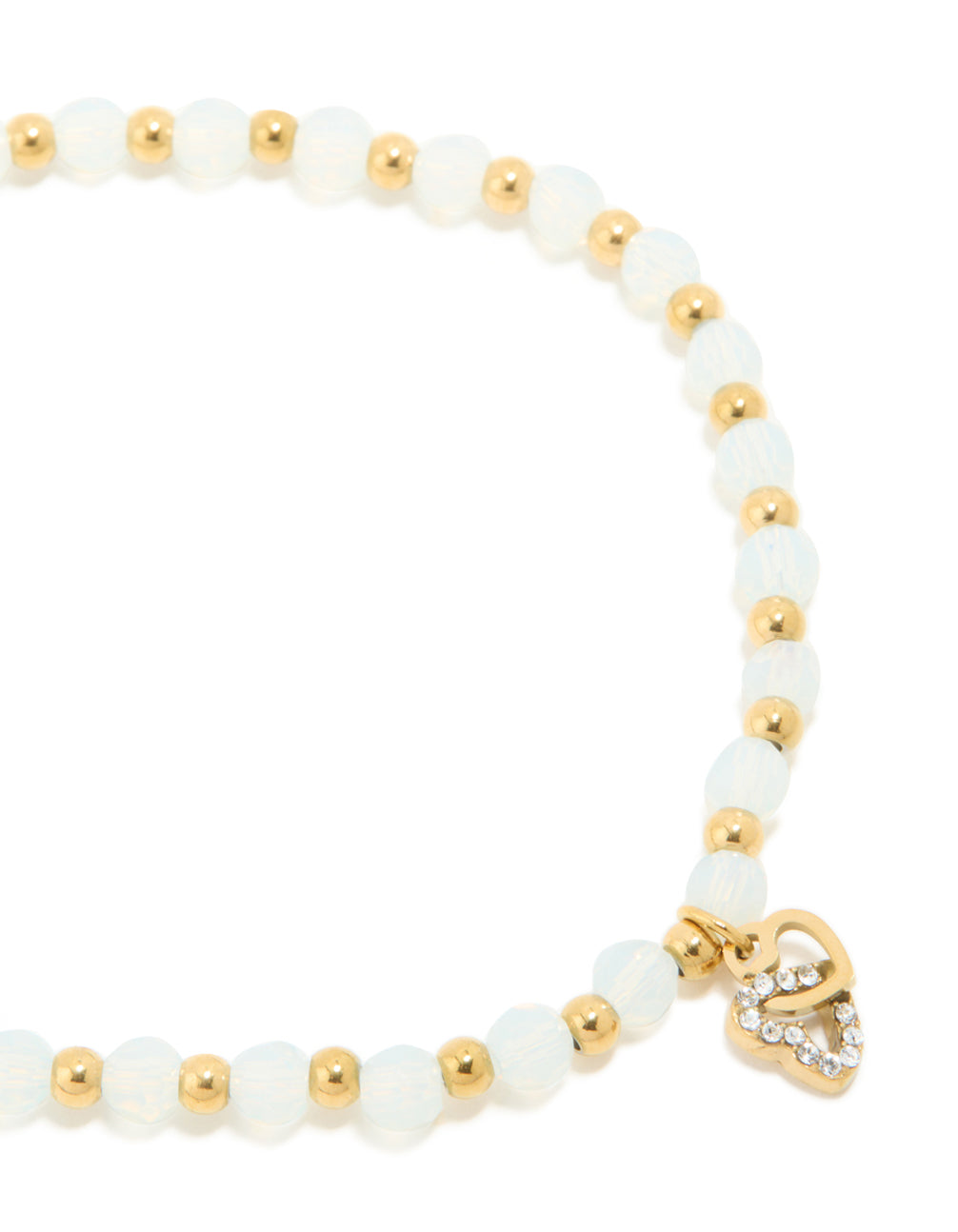 Showcasing a waterproof gold plated stainless steel beaded stretch bracelet with clear quartz stones and dainty heart charm close up view