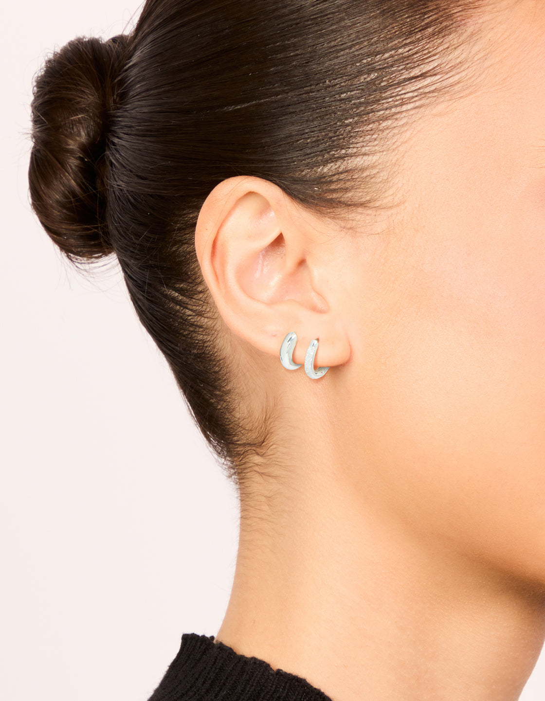 Discover waterproof stainless steel pave and plain huggie earrings in a 2-pack featuring cubic zirconia hoop closure, shown in silver on ear view