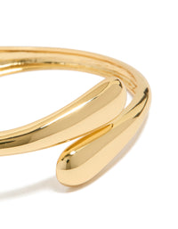 This gold plated open wrap hinged bangle highlights detailed craftsmanship in a close up view - link has visual effect only