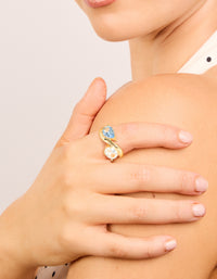 Showcasing a gold plated ring with clear and blue cubic zirconia stones on finger view - link has visual effect only
